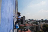 Men working on a building using rappelling equipment