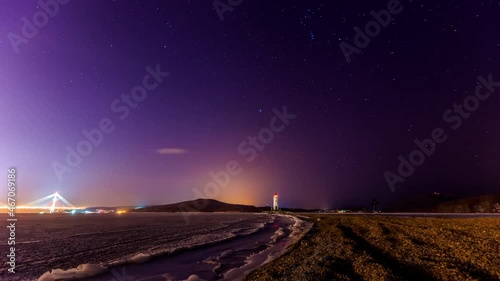 Tokarevsky lighthouse in Vladivostok. Time Laps. A picturesque lighthouse against the background of the starry sky. The Milky Way is moving around a beautiful old lighthouse. photo
