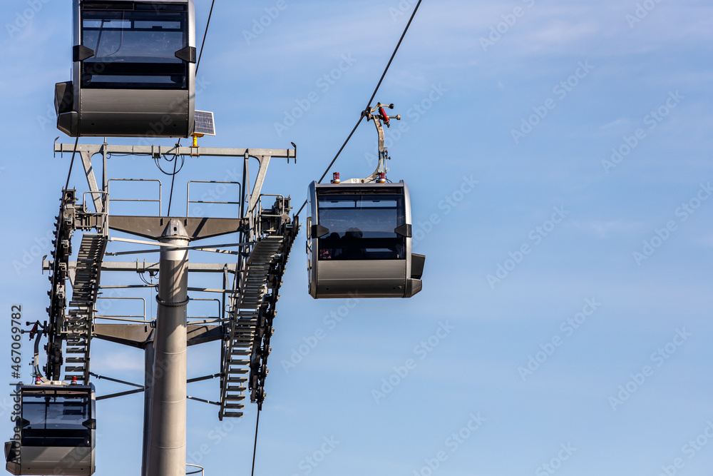 Rope way over cloudy blue sky. Funicular cabins and aerial city skyline panoramic view in Russia Rope way over cloudy blue sky. Funicular cabins and aerial city skyline panoramic view in Russia