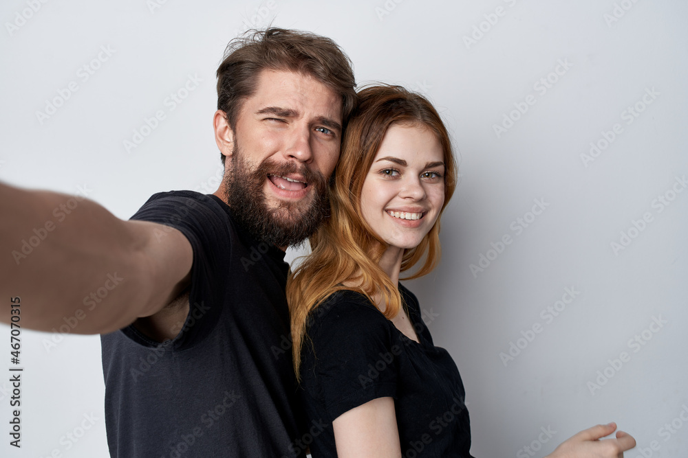 Man and woman in black t-shirts together fun friendship light background Man and woman in black t-shirts together fun friendship light background