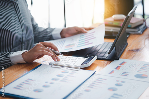 Behang business woman using calculator to do math finance statistics and tax