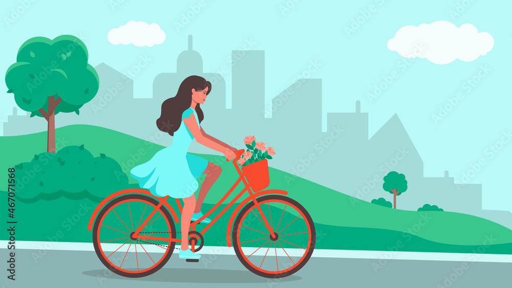 A young woman in a dress rides a bicycle through a city park with flowers in a basket .Healthy lifestyle in the city. A young woman in a dress rides a bicycle through a city park with flowers in a basket .Healthy lifestyle in the city.