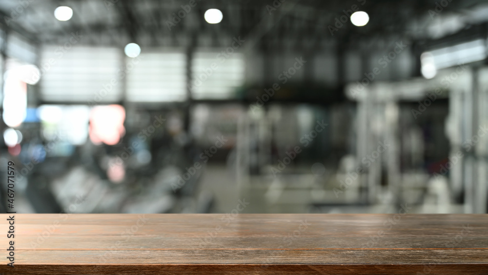 Empty wooden counter with blurred gym in background. For montage your product display.