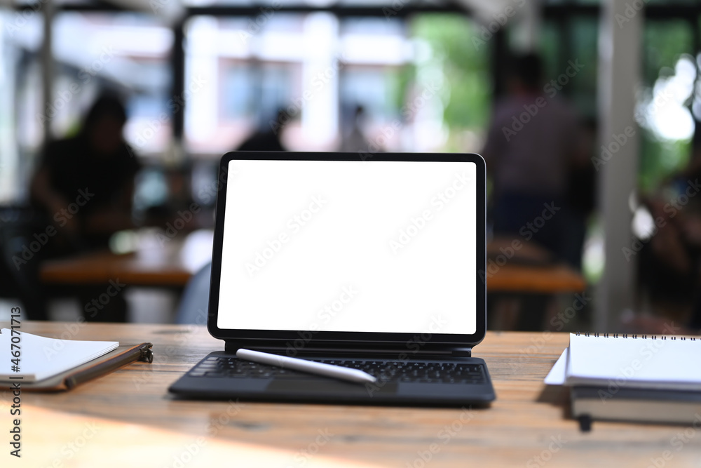 Computer tablet with empty screen, stylus pen and books on wooden table. Computer tablet with empty screen, stylus pen and books on wooden table.