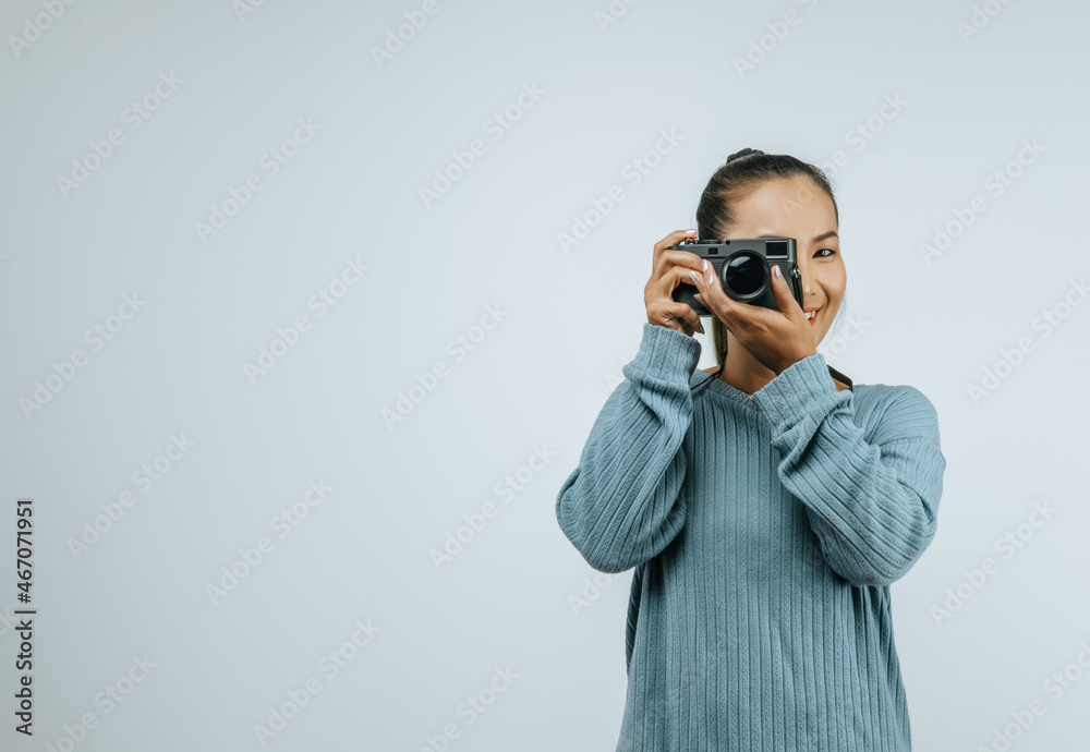 Portrait of Asian woman wearing casual clothes with a big smile on face,  taking pictures with camera. Isolated background in studio with blank space.