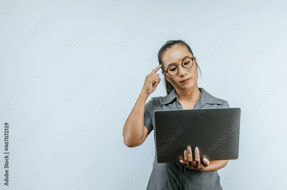 Portrait of Focused Aisan businesswoman glasses holding laptop and thinking on isolated background. SME business concept.
