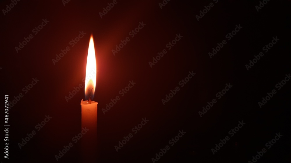 burning candle on black background which was placed left side of the background. burning candle on black background which was placed left side of the background.