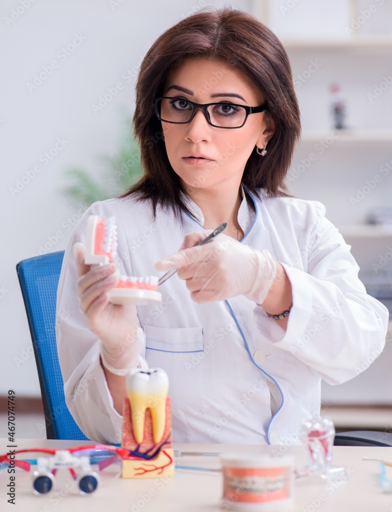 Woman dentist working on teeth implant Woman dentist working on teeth implant