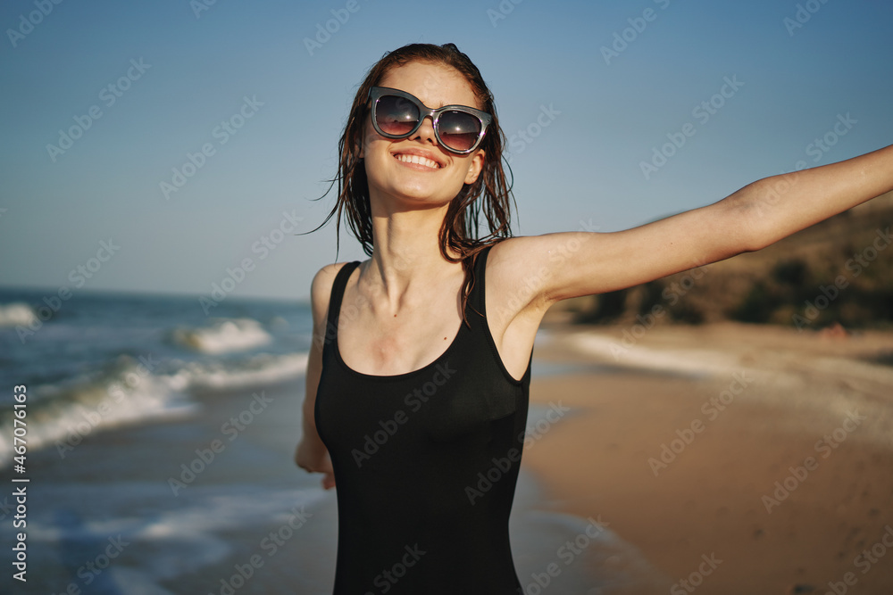 cheerful woman in a black swimsuit walking along the beach tropics summer cheerful woman in a black swimsuit walking along the beach tropics summer