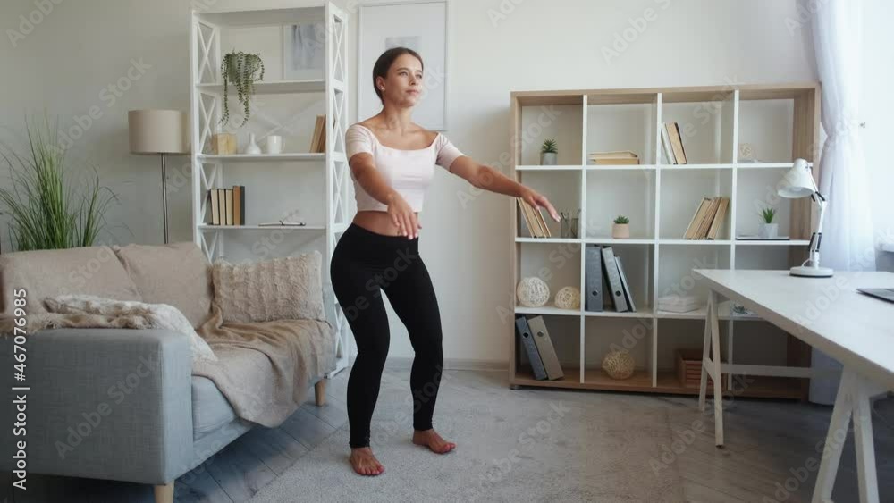 Home training. Slim woman. Healthy fitness. Happy lady doing deep squats workout in light living-room interior. Home training. Slim woman. Healthy fitness. Happy lady doing deep squats workout in light living-room interior.