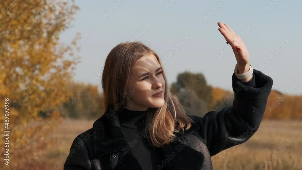 Autumn season. Young beautiful girl covers her face from the sun. Sunny weather. Autumn season. Young beautiful girl covers her face from the sun. Sunny weather.