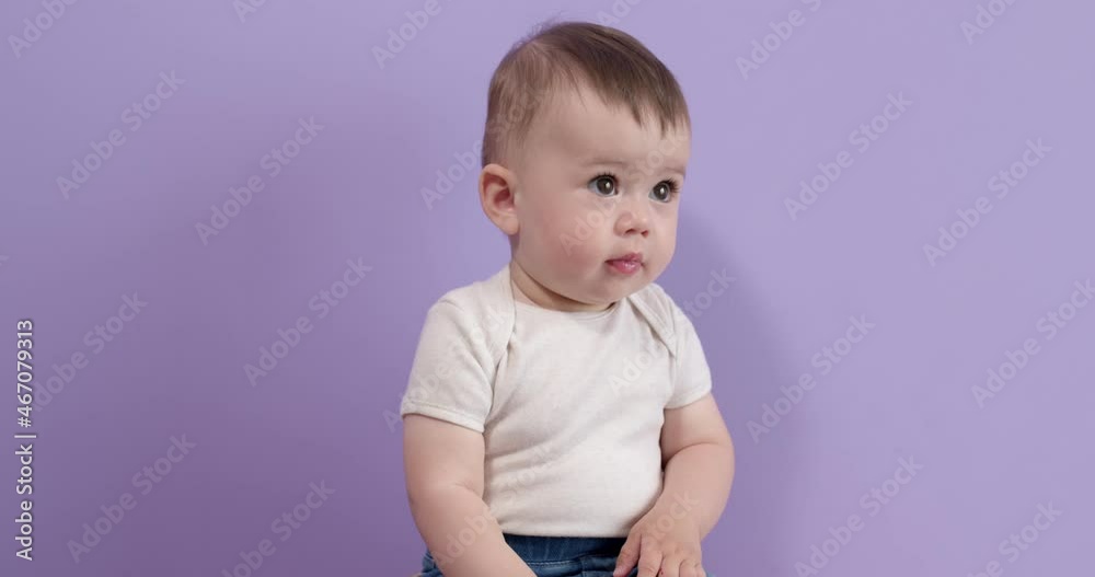 Beautiful little candy princess girl sit looking at side smiling cutely, isolated on purple studio background. Innocent pretty toddler child sit having fun, smiling, laughing. Happy childhood concept Beautiful little candy princess girl sit looking at side smiling cutely, isolated on purple studio background. Innocent pretty toddler child sit having fun, smiling, laughing. Happy childhood concept