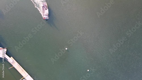 Aerial top down of salvage tug, towing submerged sailboat and dragging it towards the shore. photo