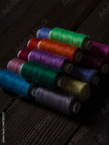 A set of sewing threads of different colours of brown on a wooden background