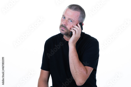 portrait of young sad frustrated handsome pensive man talking on the phone smartphone
