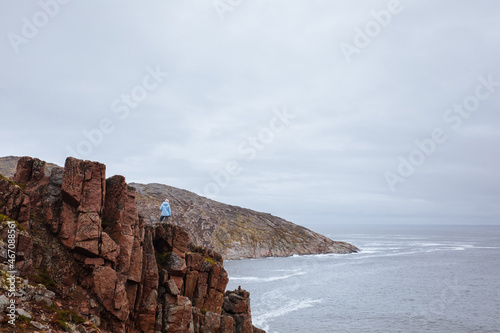 Woman watching at the coastline nearby russian village Teriberka, Murmansk region
