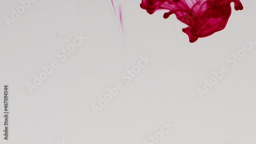 Red pigment ink water explosion from above white background.