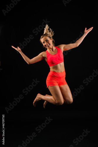 Beautiful female with dumbbells posing on studio background