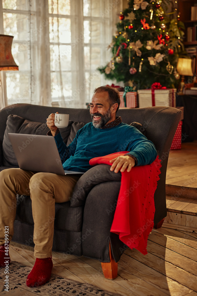 Man during video call on Christmas evening at home. Man during video call on Christmas evening at home.