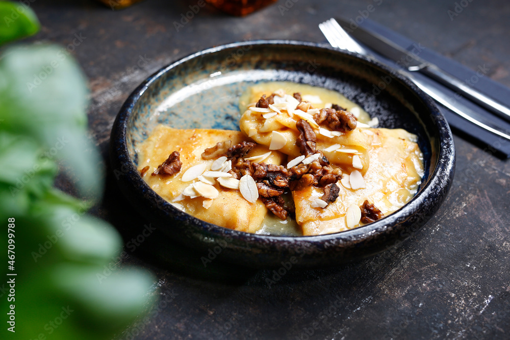 Pancakes with cheese in orange sauce served with caramelized nuts and almonds.
Appetizing dish. Culinary photography, a proposal to serve a meal.
