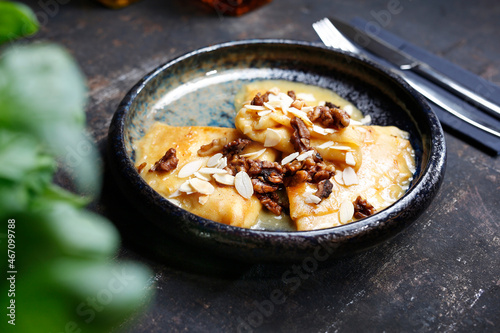 Pancakes with cheese in orange sauce served with caramelized nuts and almonds.
Appetizing dish. Culinary photography, a proposal to serve a meal.