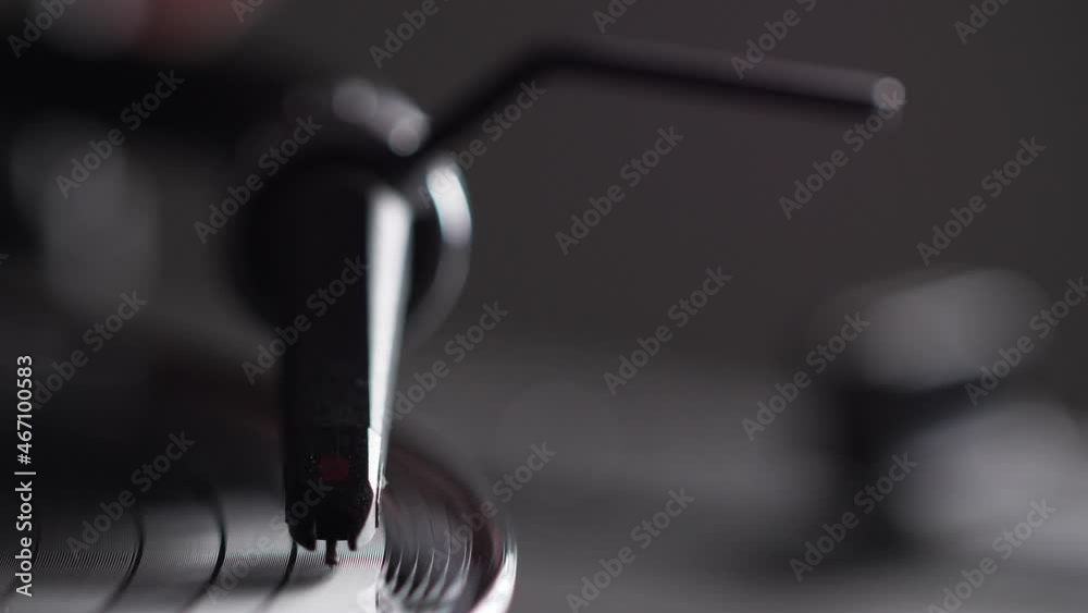 Male hand put needle on record spinning on turntable. Listening the music. Closeup Male hand put needle on record spinning on turntable. Listening the music. Closeup