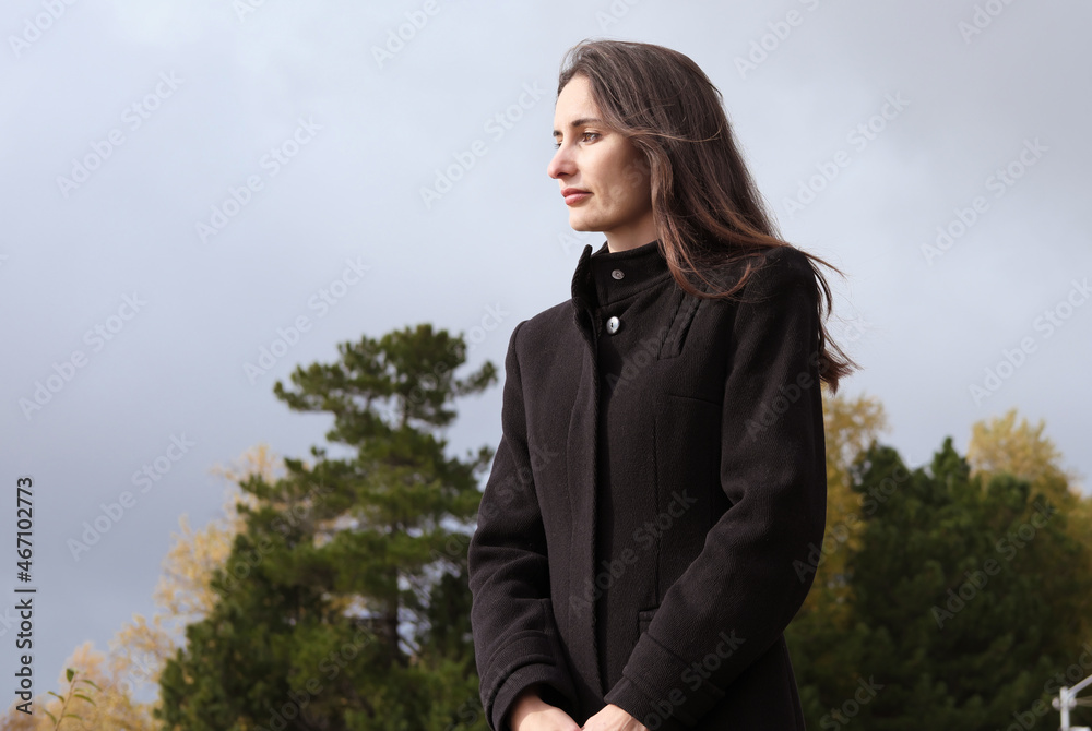 woman standing and looking aside. side view of autumn female portrait outdoors. calm and peaceful woman walking alone. woman standing and looking aside. side view of autumn female portrait outdoors. calm and peaceful woman walking alone.