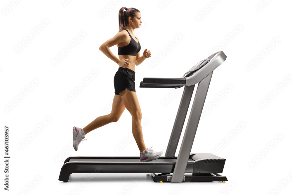 Fototapeta premium Full length profile shot of a fit young female running on a treadmill