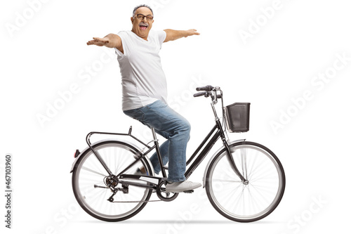 Happy mature man riding bicycle with arms wide open