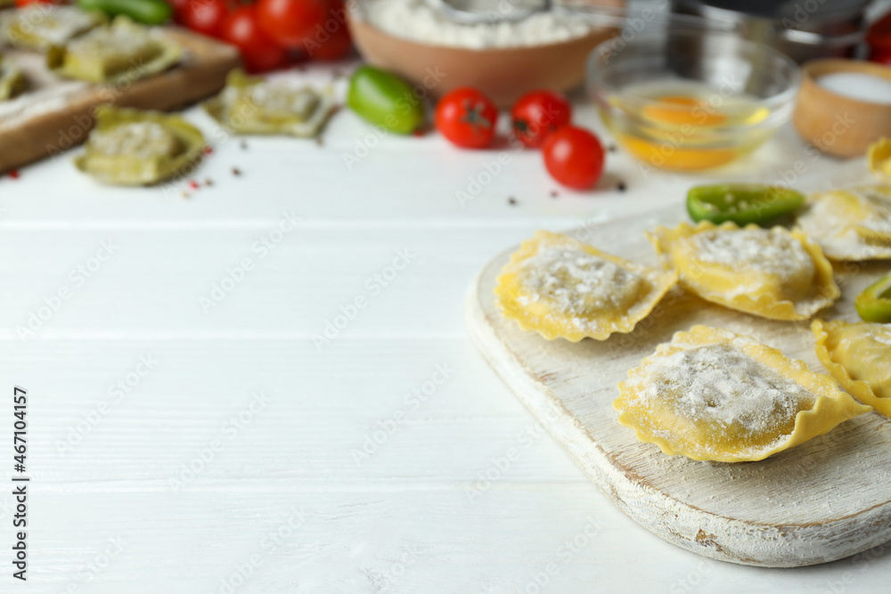 Concept of cooking ravioli on white wooden background