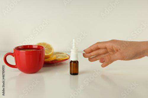 Female hand takes bottle of nasal spray, close up