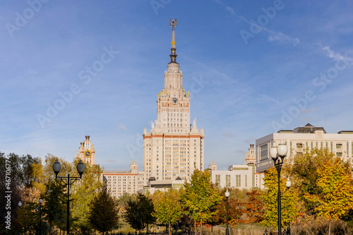 The main building of Moscow State University aka MSU or MSU on Vorobyovy Gory. Shot through an autumn park with yellowed foliage. Famous place in Russia