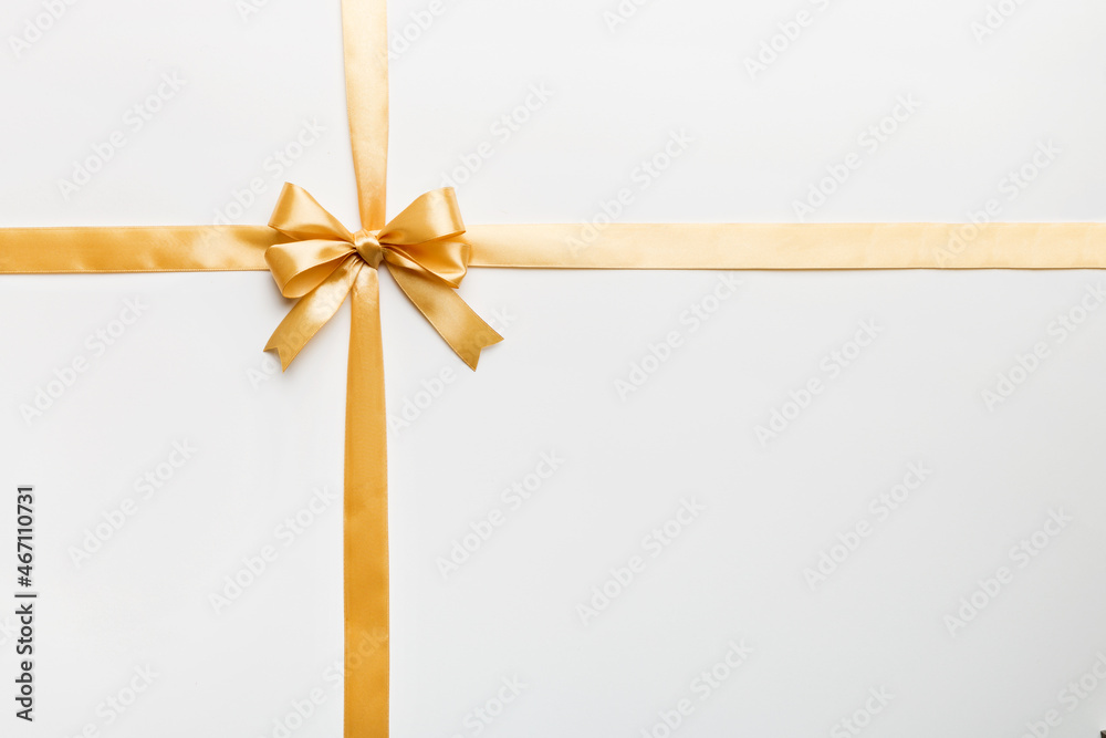 Top view of gold ribbon rolled and yellowbow isolated on colored background. Flat lay with copy space Top view of gold ribbon rolled and yellowbow isolated on colored background. Flat lay with copy space