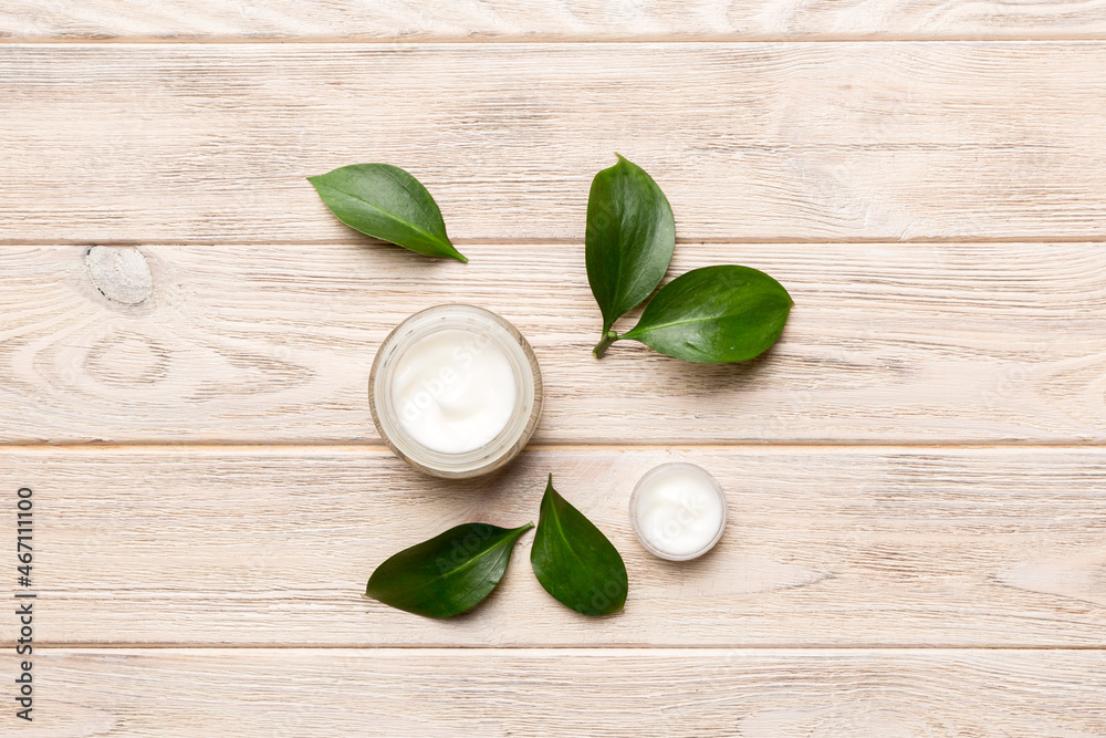 Organic cosmetic products with green leaves on wooden background. Flat lay Organic cosmetic products with green leaves on wooden background. Flat lay
