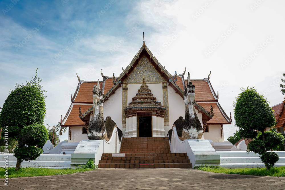 Wat Pra Tard Chang Kum Buddhist temple locate on Amphoe Mueang Nan District, Thailand with background of cloudy sky.
