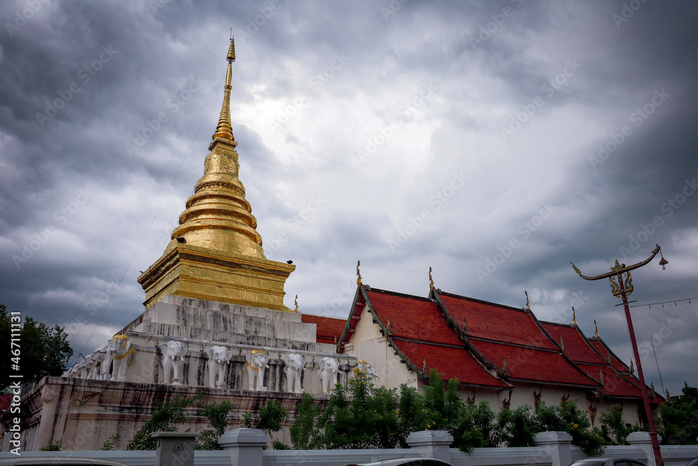 Wat Pra Tard Chang Kum Buddhist temple locate on Amphoe Mueang Nan District, Thailand with background of cloudy sky.