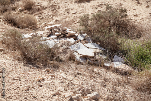 irresponsibly discarded building materials that were dumped illegally pollute a small protected stream bed in the Negev Highlands desert in Israel