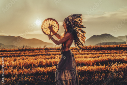 Obraz na plátně beautiful shamanic girl playing on shaman frame drum in the nature