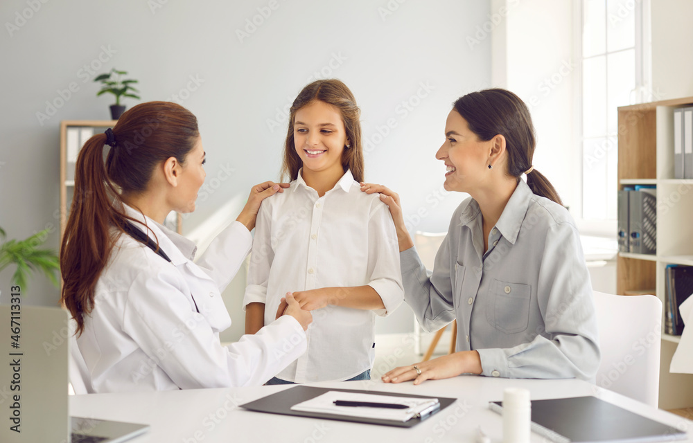 Young Caucasian mom and teen daughter at consultation with female doctor in private hospital. Happy mother and small girl child visit GP or pediatrician in clinic. Medicine, healthcare concept. Young Caucasian mom and teen daughter at consultation with female doctor in private hospital. Happy mother and small girl child visit GP or pediatrician in clinic. Medicine, healthcare concept.
