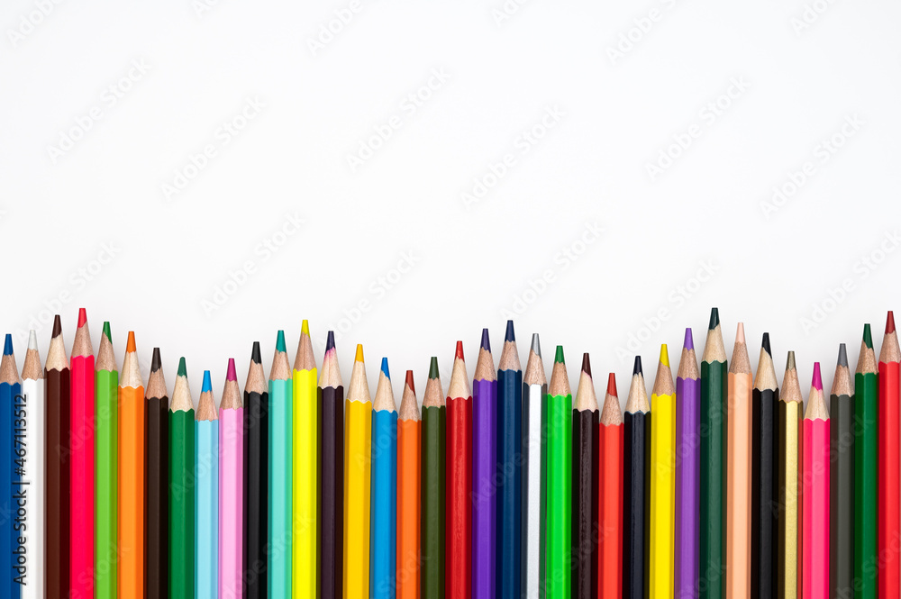 Back to school or creativity concept. Wavy frame made of colored crayons against white background. Table top view, flat lay, copy space. Back to school or creativity concept. Wavy frame made of colored crayons against white background. Table top view, flat lay, copy space.