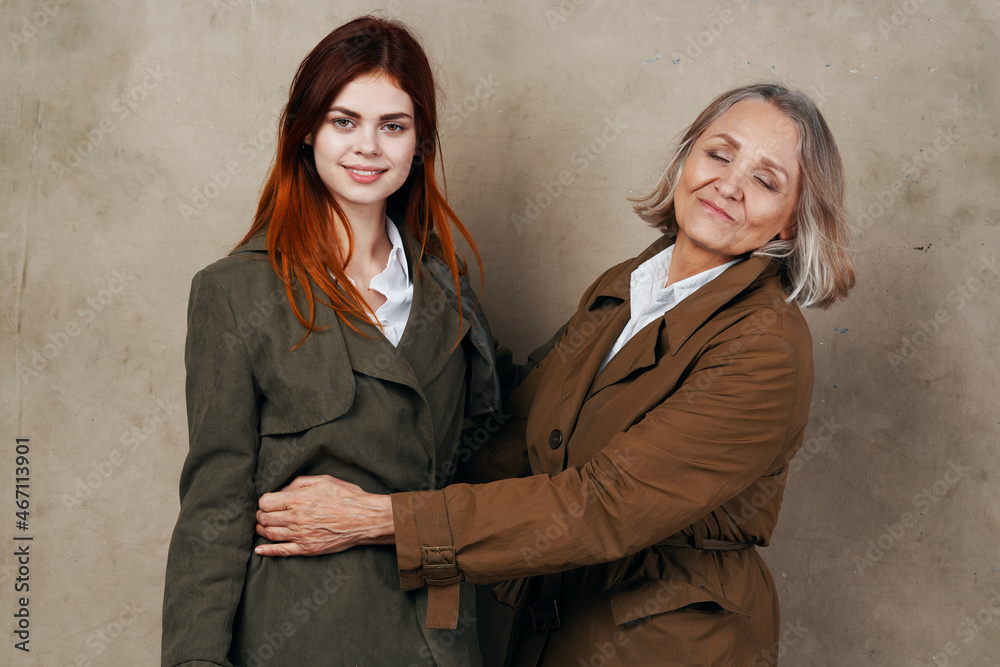 Mom and daughter in coat posing fashion autumn style Mom and daughter in coat posing fashion autumn style