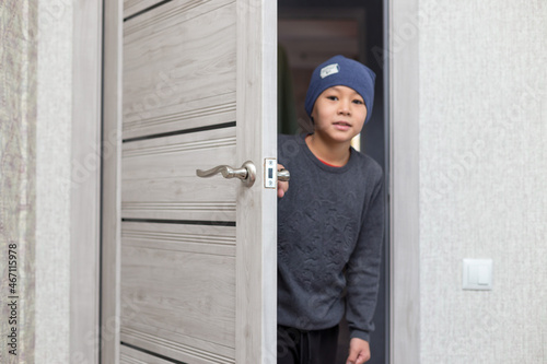 The child opens a wooden door. Go to school.