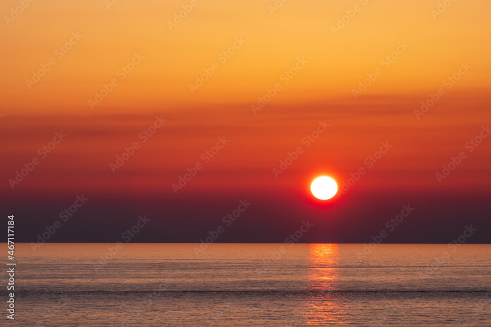 bright sun in the sky with orange clouds. seascape calm sea