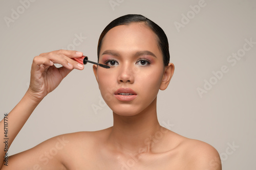 Young asian beauty model holding makeup mascara brush