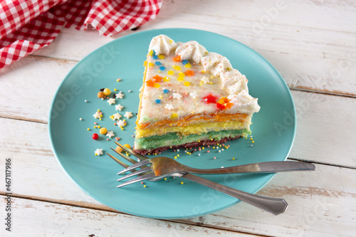 Rainbow layer cake on white wooden table