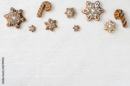Christmas homemade gingerbread cookies on the white wooden background.