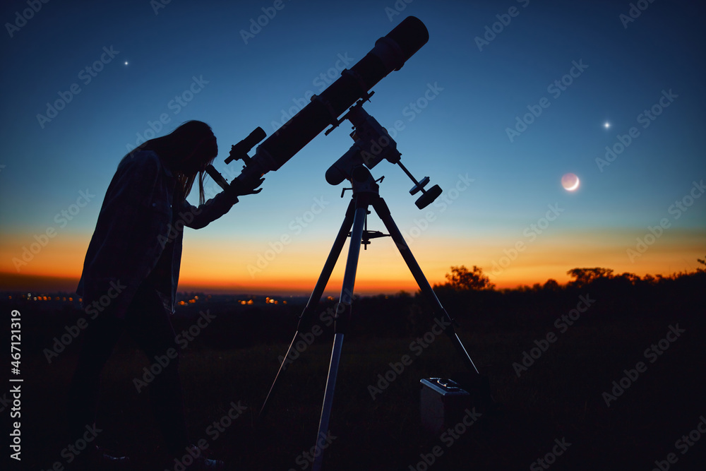 Silhouette of a woman, telescope and countryside under the starry skies.