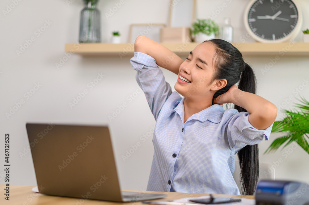 Female employee using laptop and smiling happily Female employee using laptop and smiling happily