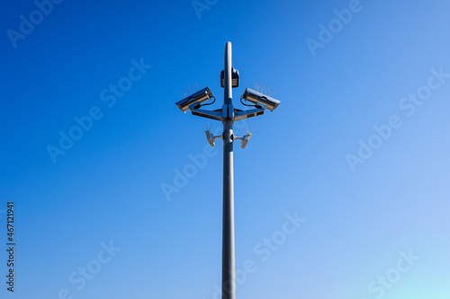 A post with several security cameras and light bulbs to control security and privacy.