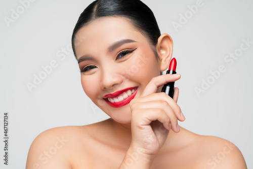 Portrait of Beautiful Asian woman with lipstick in hand